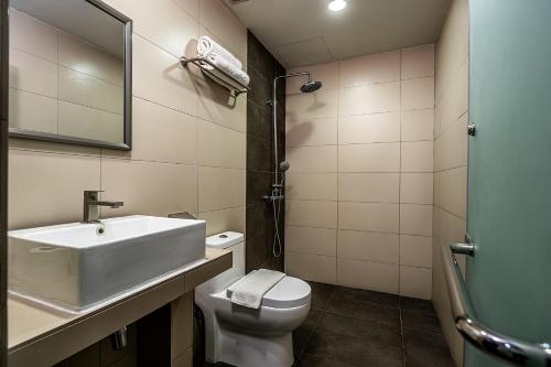 a bathroom with a sink and a toilet and a mirror at 1 Orange Hotel Kuchai Lama KUALA LUMPUR in Kuala Lumpur