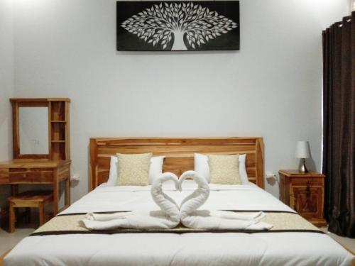 two towels in the shape of hearts are on a bed at Batur Pyramid Guesthouse in Kintamani