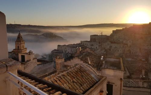 a view of a foggy city with the sun in the background at L'Affaccio in Matera