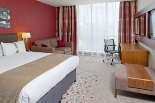 a hotel room with a large bed and a desk at Holiday Inn Bristol City Centre by IHG in Bristol