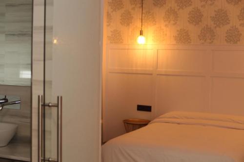 1 dormitorio con 1 cama y puerta de cristal en Hotel Cedran, en Granada