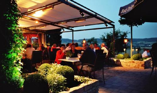 a group of people sitting at a restaurant under a canopy at Hotel Am Rosenberg in Bad Driburg