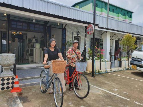 a man and a woman standing next to a bike at At Night in Chumphon