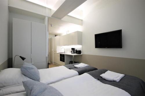 Habitación de hotel con 2 camas y TV de pantalla plana. en Forenom Aparthotel Varkaus, en Varkaus