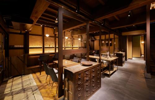 a restaurant with tables and chairs in a room at Tomonoura Shiomachi Hotel in Fukuyama