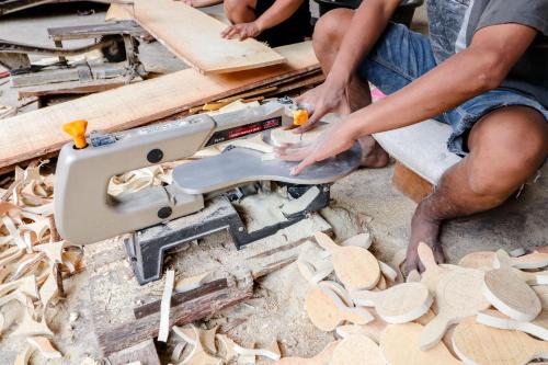 a group of people cutting wood with a chainsaw at Griya Erlangga Homestay in Yogyakarta
