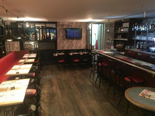 a bar with tables and chairs in a restaurant at Hotel Restaurant Cousseau in Parentis-en-Born