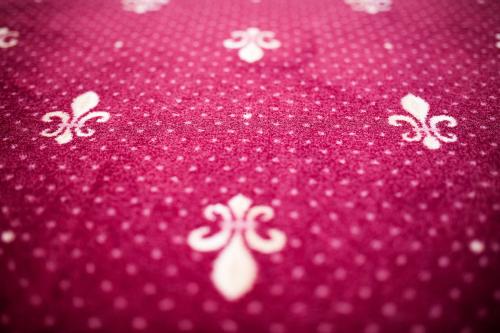 a red blanket with white flowers on it at Parkhotel Meerane in Meerane