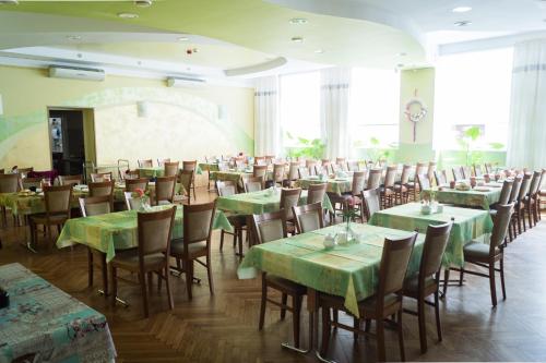 a dining room with green tables and chairs at Dom Wczasowy KAMELA in Szczytna