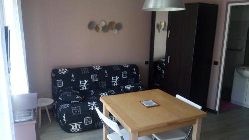 ein Wohnzimmer mit einem Tisch und einem Sofa in der Unterkunft Studio lumineux centre ville in Luchon