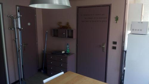 eine Küche mit einem Kühlschrank und einer Kommode neben einer Tür in der Unterkunft Studio lumineux centre ville in Luchon