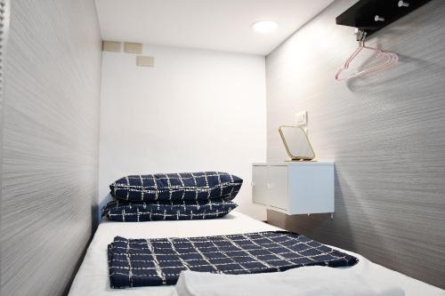 Habitación pequeña con 2 camas y una mesita de noche en 不倒翁輕旅 en Hsi-kuo-shan