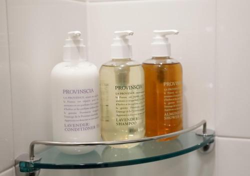 a shelf with four bottles of shampoo and conditioner at HOTEL FORZA HAKATAEKI CHIKUSHIGUCHI Ⅱ in Fukuoka
