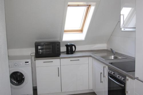 a small kitchen with a microwave and a sink at Apartment mit Rheinblick in Wesseling