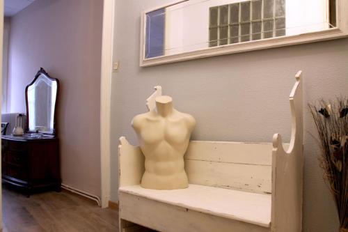 a mannequin sitting on a bench in a room at Casa l'avia in Ribes de Freser