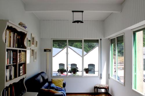 a living room with two windows and a couch at Casa l'avia in Ribes de Freser