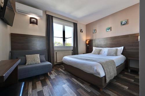 Habitación de hotel con cama y silla en Hôtel La Rotonde, en La Ciotat