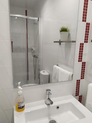bagno bianco con lavandino e doccia di Casa da Leninha a Nazaré