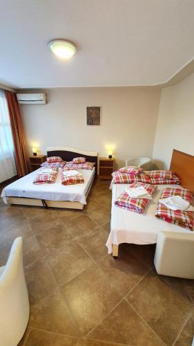 
a hotel room with two beds and two tables at Hotel Róz in Szentendre

