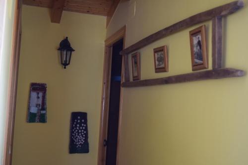 a hallway with a wall with pictures and a lamp at Casa Rural Abuelo Adón in Baterna