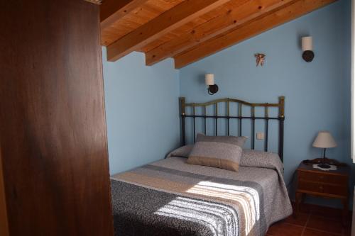 1 dormitorio con cama y techo de madera en Casa Rural Abuelo Adón en Baterna