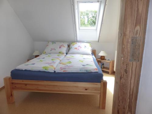 a bed in a room with a window at Friesenwohnung in Norden