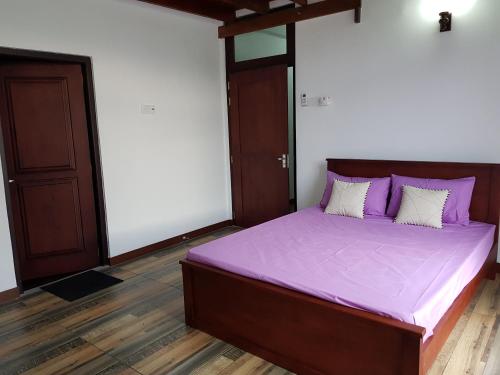 1 cama con sábanas moradas en una habitación en ELDORADO RESIDENCY 3 BR BRAND NEW FULLY FURNISHED Apartment en Wattala