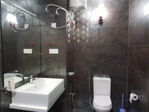 a bathroom with a sink and a toilet and a mirror at ELDORADO RESIDENCY 3 BR BRAND NEW FULLY FURNISHED Apartment in Wattala