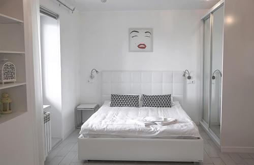 チェレポヴェツにあるApartment Naberezhnaya 33の白いベッドルーム(壁に面したベッド1台付)
