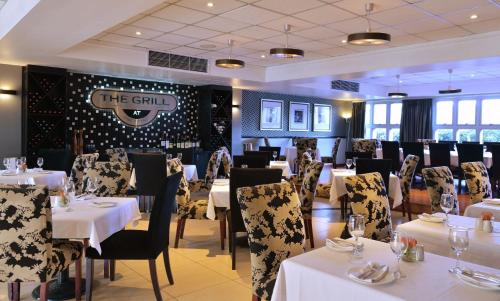 a dining room with tables and chairs and a sign at Birchwood Hotel and OR Tambo Conference Centre in Boksburg