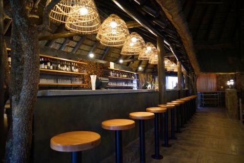 a row of stools in a bar with chandeliers at Birchwood Hotel and OR Tambo Conference Centre in Boksburg