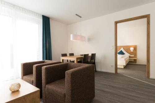 a living room with a couch and a table and a mirror at Boardinghouse E68 in Schliengen