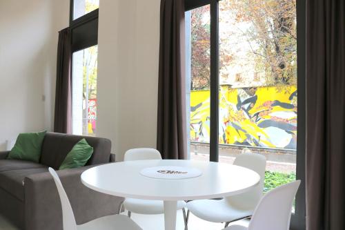 ein Wohnzimmer mit einem weißen Tisch und einem Sofa in der Unterkunft Via Magolfa - Heart of Canals in Mailand