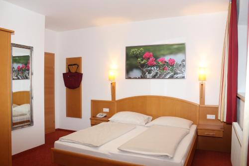 a bedroom with a bed and a mirror at Der Sailer Hotel & Restaurant in Obertauern