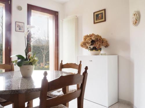 a dining room with a table and a refrigerator at Casa con vista Forte - tra lago e monti in Rivoli Veronese