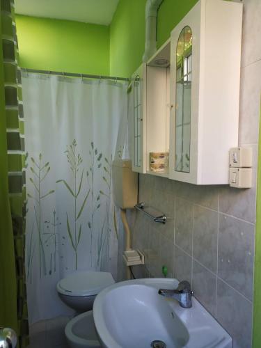 a bathroom with a sink and a toilet and a shower curtain at Hotel Simon in Rimini