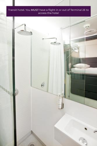 a bathroom with a sink and a mirror at YOTELAIR Paris CDG - Transit Hotel - Terminal 2E in Roissy-en-France