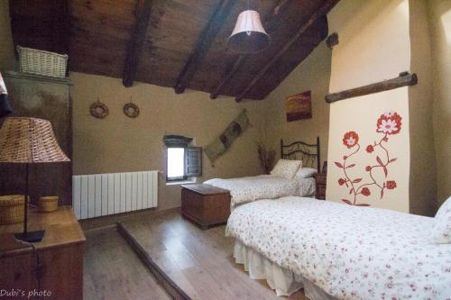 una camera da letto con due letti e soffitto in legno di La Casita de Leire a Tamajón