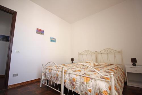 a bed in a room with a white wall at Casa Vacanza Valle della Cupa in Novoli