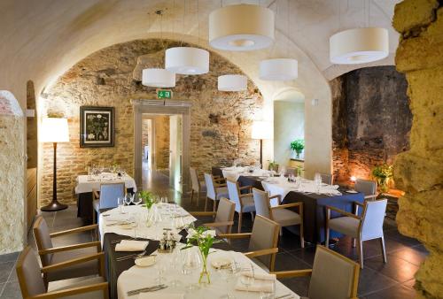 ein Restaurant mit Tischen und Stühlen und einer Steinmauer in der Unterkunft Uroczysko Siedmiu Stawów in Gola Dzierżoniowska