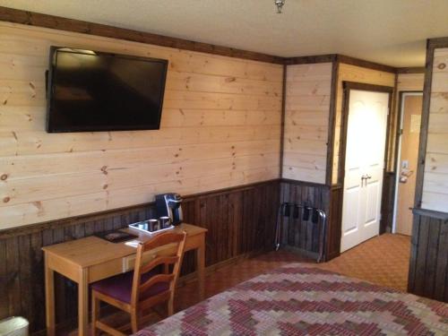 a room with a desk and a television on a wall at Reid Ridge Lodge in Blue Ridge