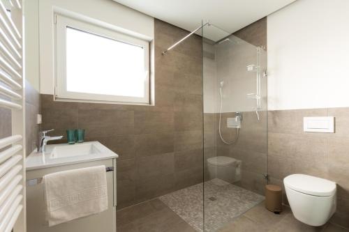 a bathroom with a shower and a toilet and a sink at Boardinghouse E68 in Schliengen