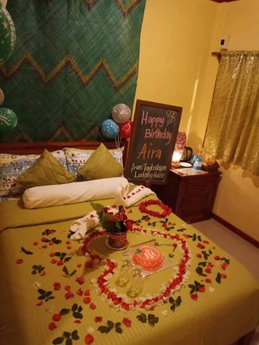 a bed with a flower arrangement on it with a happy birthday sign at TAGBALAYON Lodging House in Siquijor