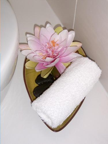 a pink flower in a vase with a towel at La Villa Camille in La Creche