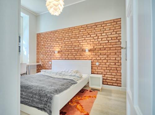 um quarto com uma parede de tijolos e uma cama em 3D WYGODA Apartamenty na Cracóvia