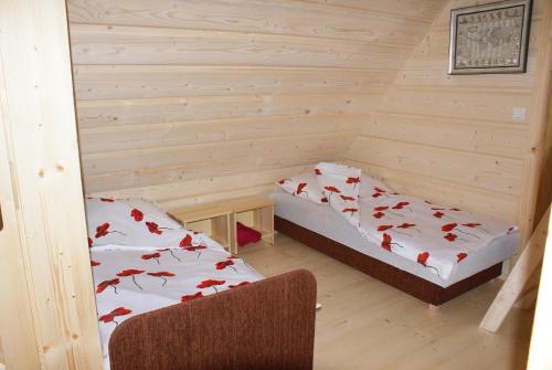 a room with two beds in a log cabin at Ostoja Karlików - Domki do Wynajęcia in Bukowsko