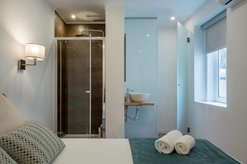 a bedroom with a shower and two towels on a bed at Beautiful Downtown Apartment in Lisbon