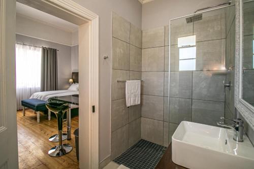 ein Badezimmer mit Dusche, Waschbecken und Badewanne in der Unterkunft Victorian Square Guesthouse in Graaff-Reinet