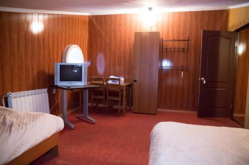 a room with a bed and a desk with a television at Europa in Ulyanovsk