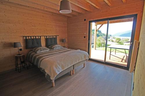 - une chambre avec un lit et une grande porte coulissante en verre dans l'établissement l'Edelweiss, à Gérardmer